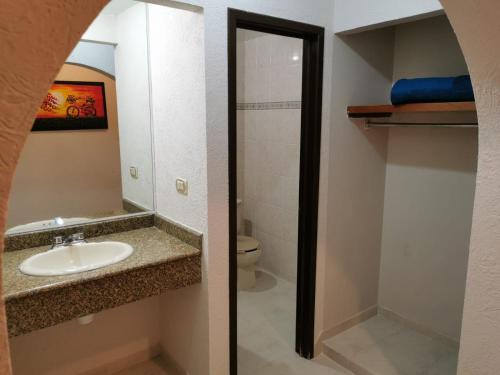y baño con lavabo y aseo. en Hotel Mexico en Xalapa