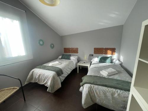 巴埃薩的住宿－Donde habita el olvido，一间卧室设有两张床和窗户。