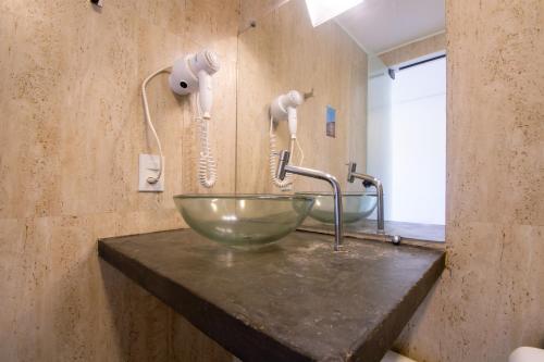 a bathroom with a glass bowl sink on a counter at Hotel Barra da Lagoa by Latitud Hoteles in Búzios