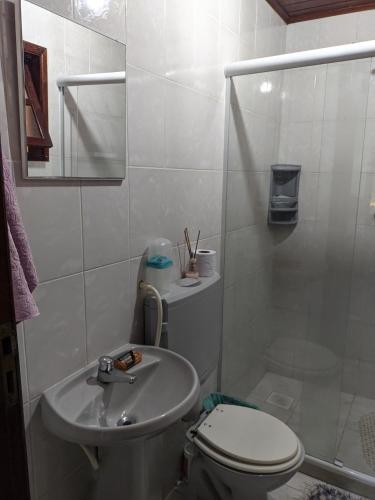 La salle de bains est pourvue de toilettes, d'un lavabo et d'une douche. dans l'établissement Região dos Lagos - casa para temporada, à São Pedro da Aldeia