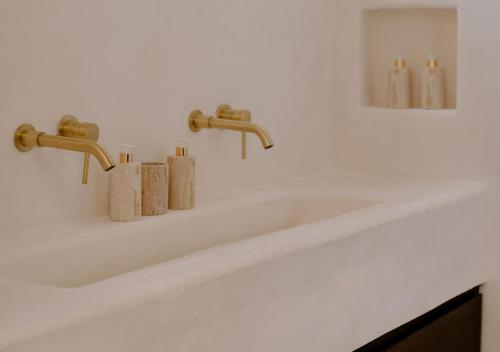 a bathroom sink with two faucets on a counter at Hotel Milam in Tulum