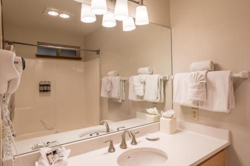 ein Badezimmer mit einem Waschbecken und einem großen Spiegel in der Unterkunft Inn at Cannon Beach in Cannon Beach