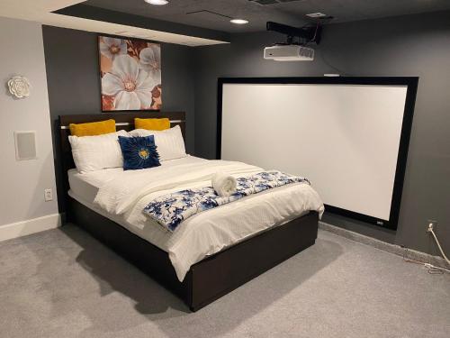 una camera con un grande letto con schermo bianco di Fully furnished basement studio apartment a Mississauga