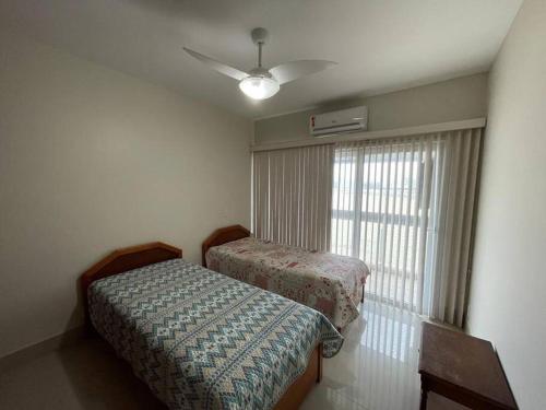 - une chambre avec 2 lits et une fenêtre avec un ventilateur dans l'établissement Vista Mar na Barra da Tijuca, à Rio de Janeiro