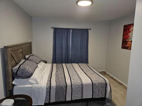 ein Schlafzimmer mit einem Bett mit einer gestreiften Decke und einem Fenster in der Unterkunft Cozy and quiet apartment in Sudbury