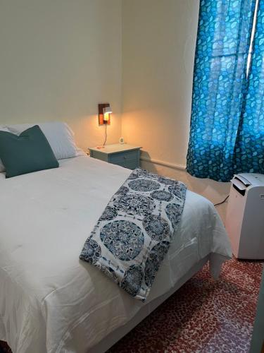 a bedroom with a bed with a blanket on it at Spa Apartment in Mayaguez