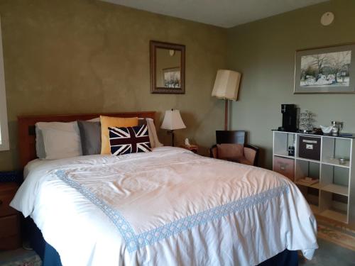 a bedroom with a large bed and a chair at Rae Leigh Heights BnB in Saanichton