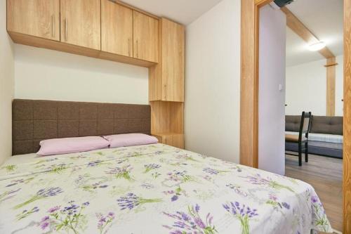 a bedroom with a bed with a floral bedspread at Apartments with parking space Babino Polje, Mljet - 22319 in Babino Polje