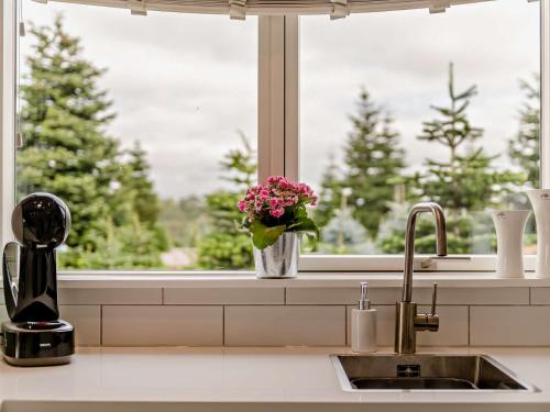 a kitchen sink with a vase of flowers in a window at 2 Bed in Totnes 93062 in Marldon