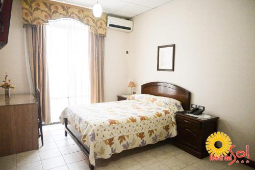 a bedroom with a bed and a window at Hotel del Sol in Tarija