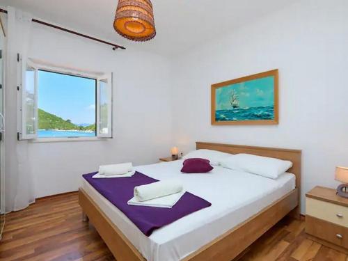 ein Schlafzimmer mit einem großen weißen Bett mit einem Fenster in der Unterkunft Apartments by the sea Prozurska Luka, Mljet - 22338 in Prožura