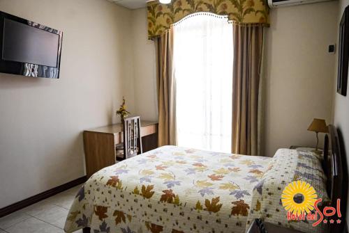 a bedroom with a bed and a large window at Hotel del Sol in Tarija