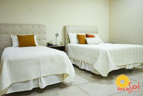 two beds sitting next to each other in a bedroom at Hotel del Sol in Tarija