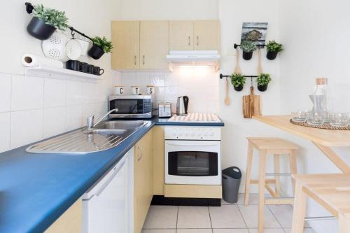 a small kitchen with a sink and a stove at Live in the heart of Surry Hills - walk to City in Sydney