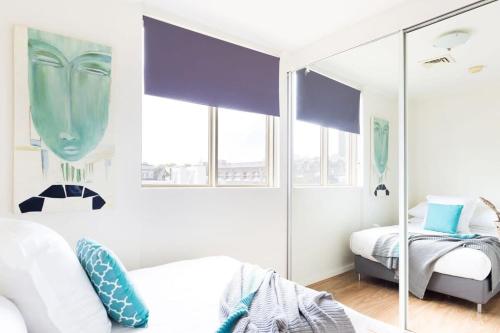 a bedroom with two beds and a mirror at Live in the heart of Surry Hills - walk to City in Sydney