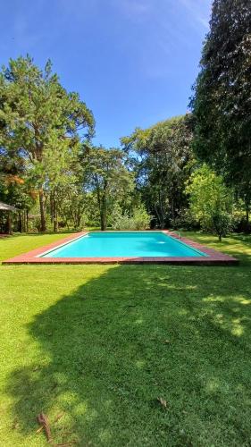 une grande piscine bleue dans une pelouse dans l'établissement Sitio Na Serra da Mantiqueira, à Piranguçu