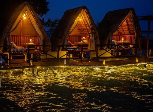 un complejo con una piscina de agua por la noche en El Búho Lagoon Bacalar, en Bacalar