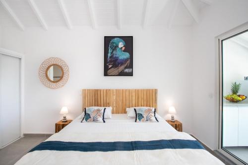 1 dormitorio con 1 cama extragrande y espejo en Beautiful suite S12 with pool and sea view, en Cul de Sac