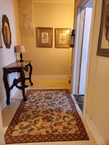 a hallway with a rug on the floor next to a door at Stone Carriage House in Picton