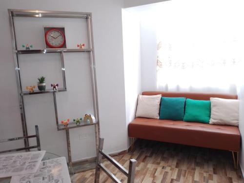 ein Wohnzimmer mit einem roten Sofa und Regalen in der Unterkunft Departamento centrico de lujo en Huancayo in Huancayo