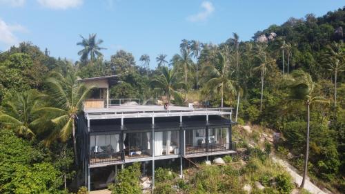 a house on top of a hill with trees at Ozone Hill Panoramic Residence Thong Nai Pan Beach in Thong Nai Pan Noi