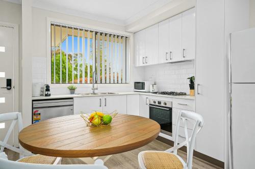a kitchen with a wooden table with a bowl of fruit on it at Charming 2-Bed Moss Vale Getaway in Moss Vale