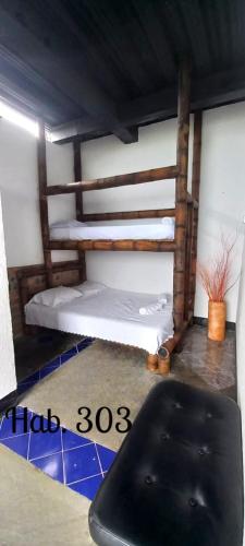 a room with two bunk beds and a black chair at Villa Tikuna in Mariquita
