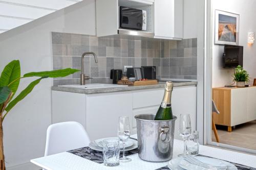 eine Küche mit einem Tisch und einer Flasche Wein in der Unterkunft Beautiful suite S12 with pool and sea view in Cul de Sac