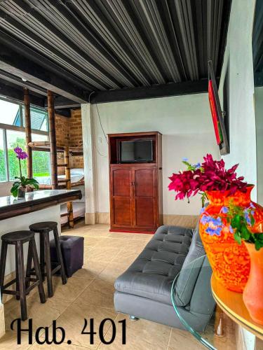 a living room with a couch and a tv at Villa Tikuna in Mariquita