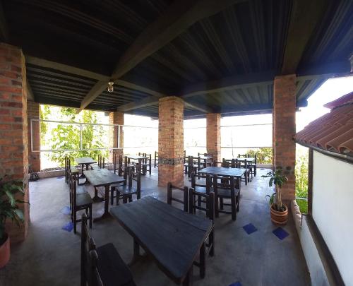 an empty patio with tables and chairs in a restaurant at Villa Tikuna in Mariquita