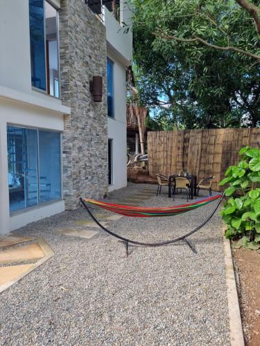 a hammock in the backyard of a house at Cabaña de Lujo, Isla El Faro in Prado