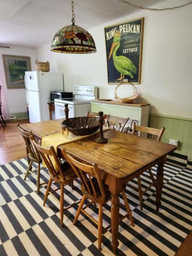 a dining room with a wooden table and chairs at Stone Carriage House in Picton