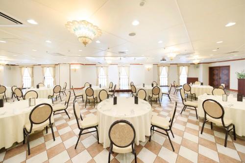 una sala banchetti con tavoli, sedie e lampadario a braccio di Hirosaki Park Hotel a Hirosaki