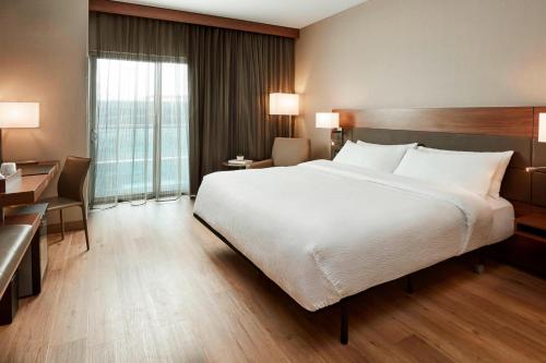 a hotel room with a large bed and a desk at AC Hotel by Marriott Cincinnati at The Banks in Cincinnati