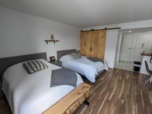 Duas camas num quarto com pisos em madeira em Bienvenue chez Alice et daniel em Saint-Férréol-les-Neiges