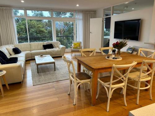 a living room with a wooden table and chairs at Kingston Beach Home - Beach & Bush Views in Kingston Beach