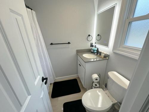 a bathroom with a white toilet and a sink at Seaside Serenity: Cozy Retreat on Bay Drive in Kill Devil Hills