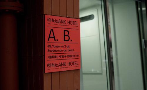 a sign on the side of a wall next to a door at Aank Hotel Seoul Sinchon in Seoul