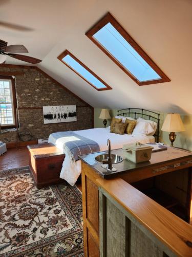 a bedroom with a bed with a sink and skylights at Stone Carriage House in Picton