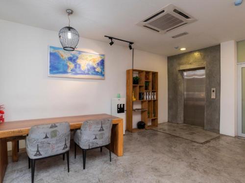 a dining room with a wooden table and two chairs at Big Big Hotel in Johor Bahru