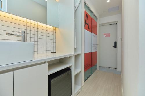 a bathroom with a sink and a door at Aank Hotel Seoul Sinchon in Seoul
