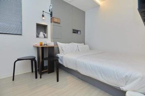 a bedroom with a bed and a small table at Aank Hotel Seoul Sinchon in Seoul