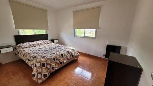 a bedroom with a bed and two windows at Lago fagnano 23 in Tolhuin
