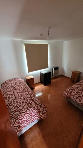 a room with two beds and a flat screen tv at Lago fagnano 23 in Tolhuin