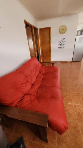 a red couch in a room with a refrigerator at Lago fagnano 23 in Tolhuin