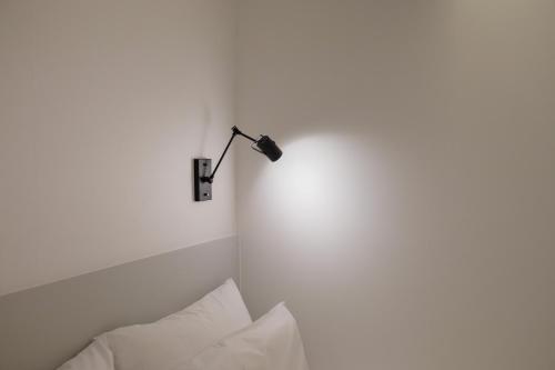 a white room with a lamp on the wall at Aank Hotel Seoul Sinchon in Seoul
