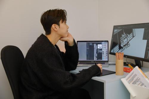 a man sitting at a desk with a laptop computer at Aank Hotel Seoul Sinchon in Seoul