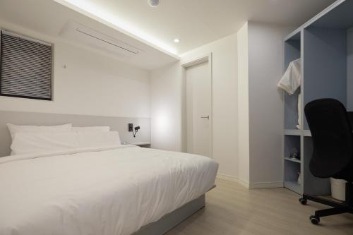 a bedroom with a bed and a desk and a chair at Aank Hotel Seoul Sinchon in Seoul
