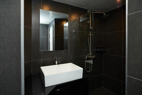 a bathroom with a white sink and a mirror at Aank Hotel Seoul Sinchon in Seoul