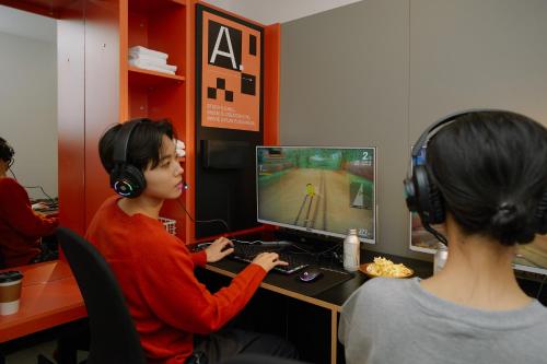 a woman wearing headphones playing a video game on a computer at Aank Hotel Seoul Sinchon in Seoul